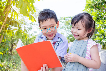 男孩给他的妹妹在公园里读故事