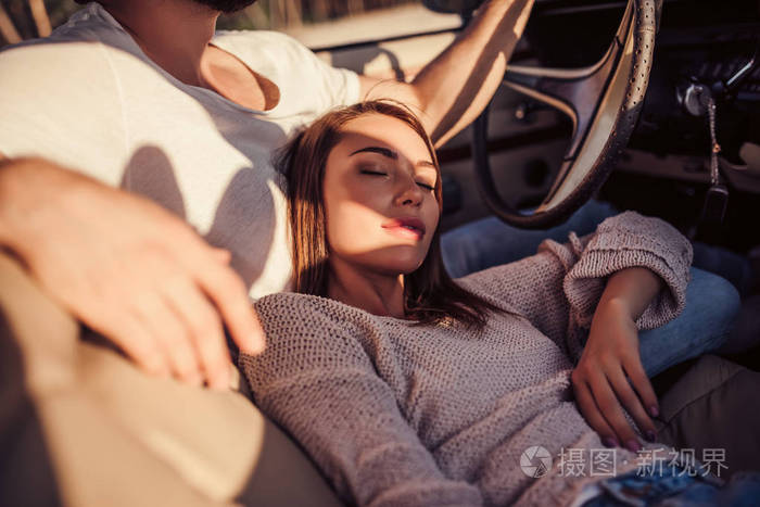 英俊的胡子男子和漂亮的年轻女子在老式的经典轿车.时尚的爱情故事.