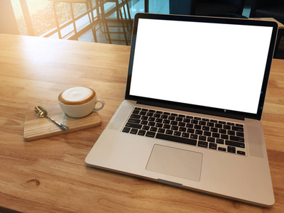 咖啡杯和内咖啡厅的木桌上的笔记本电脑。经营理念