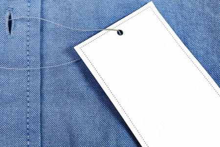 蓝色男士衬衫上的白色纸标签。在产品上制作价格标签或折扣信息