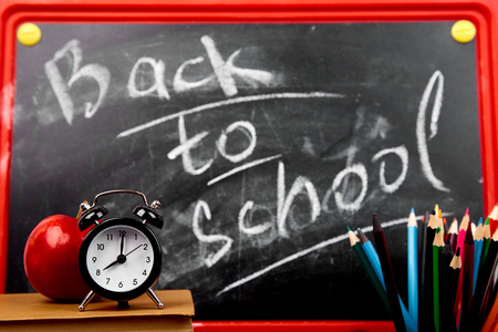 回到学校刻字黑板上的粉笔与书, 铅笔, 红苹果近黑板背景