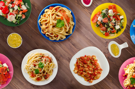 餐桌上有蔬菜和调味汁的面食。盘子上的意大利面。地中海美食
