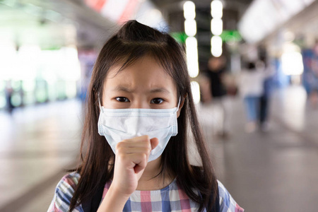 亚洲女孩患咳嗽与面罩保护, 生病的女孩与医疗面罩, 健康概念