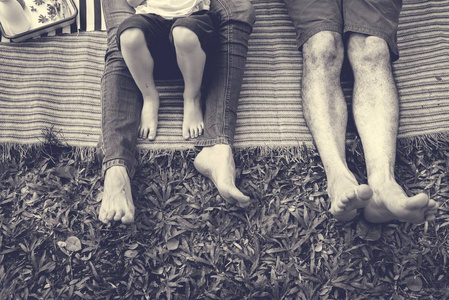 野餐时躺在毯子上的一家人图片