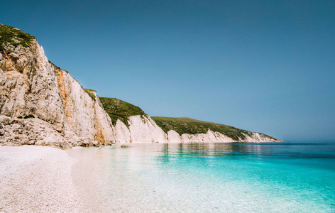 Fteri 海滩在凯法利尼亚岛, 希腊。一个最美丽的未触及的卵石海滩与纯净的蔚蓝翡翠海水包围的高白色岩石峭壁凯法利尼亚