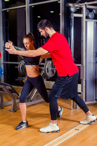 健身 运动 训练和人的概念   在健身房工作与私人教练帮助女人