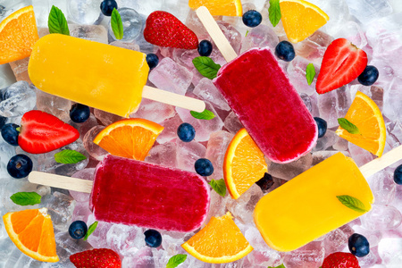 刷新在冰背景的浆果，水果冰棒糖果薄荷