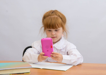 这个小女孩在表拿着粉色的手机