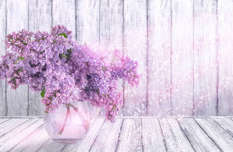 室内与丁香花在桌子上的玻璃花瓶在破旧别致的风格在木墙背景与地方为