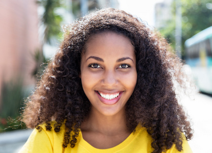 黄色衬衫在城市中的黄色衬衫美丽的拉丁女人照片