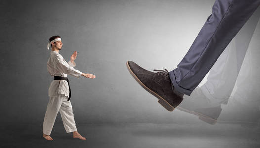 大脚踩着小空手道的男人照片