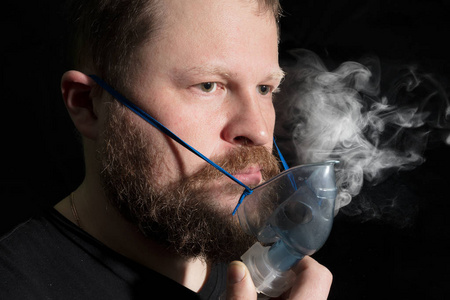 通过雾化器面罩呼吸的人图片