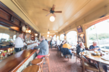 模糊的抽象原始的爱尔兰咖啡餐厅在美国旧金山。酒保在酒吧柜台与顾客交谈
