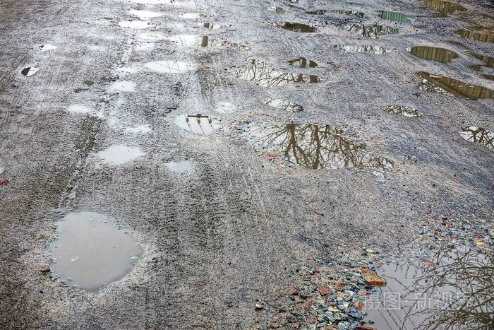 褐色的地球和路上的水坑