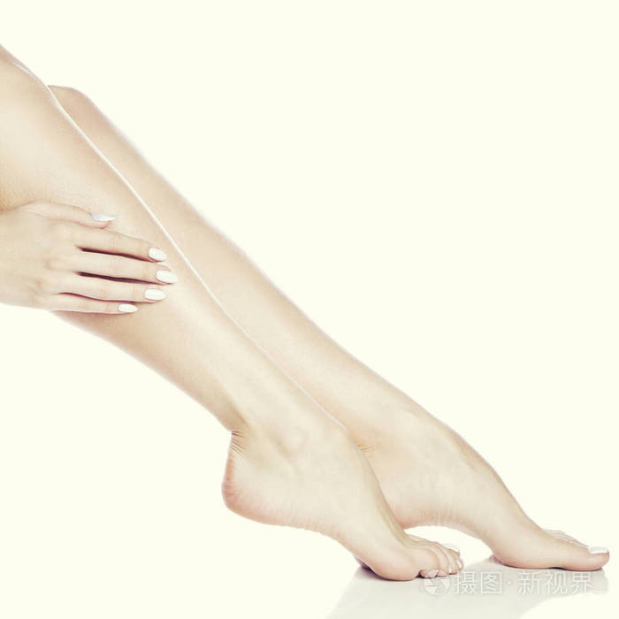 女性脚和手的侧面在白色的背景指甲