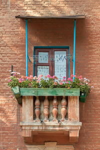 老式浪漫阳台与木窗框, 花边窗帘和栏杆在一个老房子与花盆