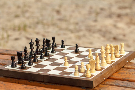 国际象棋棋盘与棋子在木凳上。户外棋 ga