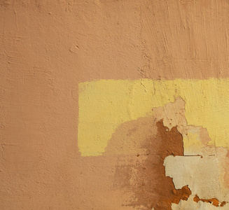 老破旧的黄墙上一块文本。纹理背景