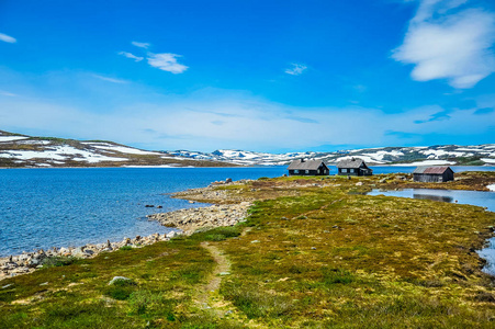 孤立的房舍包围的小山和山的美丽景观部分覆盖着皑皑的白雪 挪威