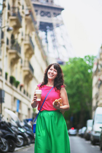 法国巴黎的街上走去的咖啡和面包的女人