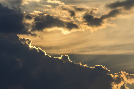 在晴朗的天空上, 明亮的橙色黄色的太阳照亮了美丽的蓝色云彩.