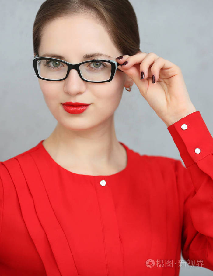 时尚商务女人与红色的衬衫和眼镜画像,手里拿着太阳镜