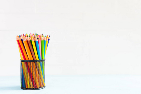 教育或回到学校概念。学校办公用品。彩色铅笔盒上白色木质背景