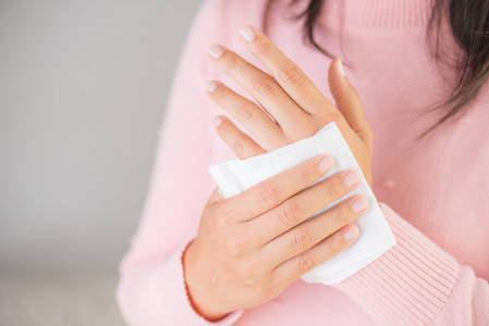 女人用纸巾擦手。医疗保健理念