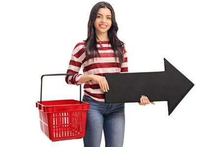 女人抱着一个购物篮和箭头