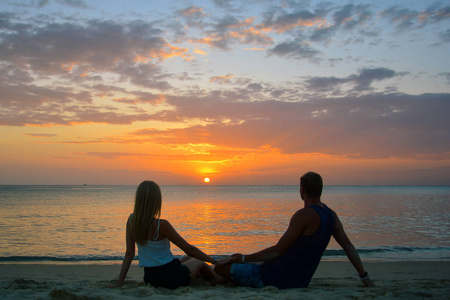 夫妇在沙滩上看日落