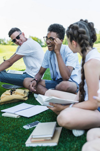 快乐的多民族青少年学生在公园一起学习微笑