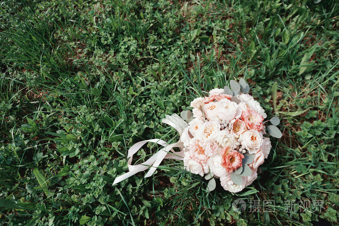 美丽的婚礼花束的花和绿色的草地上丝带.玫瑰