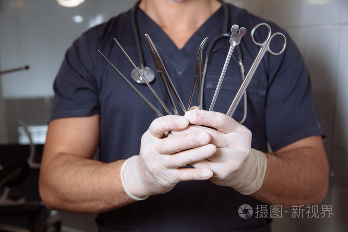 外科医生在手术室里满头在他手中的医疗工具