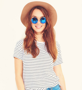 年轻时尚的笑女孩的肖像在休闲夏季衣服在白色背景下的棕色帽子孤立的模型