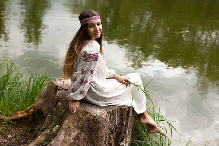 美丽的细长乌克兰在池塘的岸边刺绣享受夏日阳光明媚的一天的性质