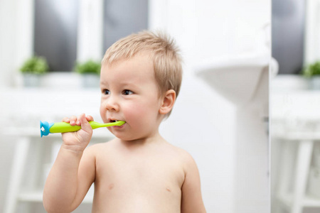 可爱的孩子学习如何在浴室刷牙