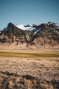 冰岛典型的山冬天场面以草在前景和大山在背景上