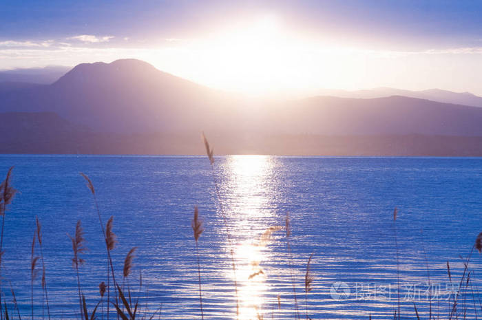 清晨的全景.山在剪影和上升的耀眼的太阳的光芒.