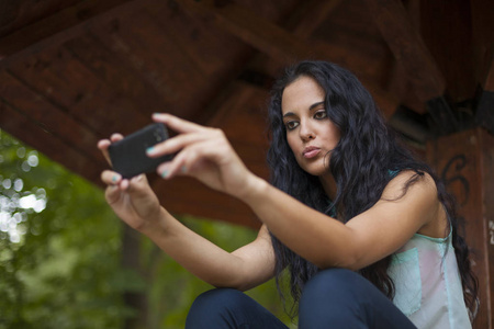 社交网络混合的种族年轻女子使用智能手机。他用电话和朋友联系。