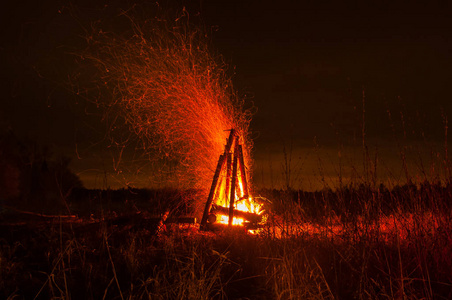 背景上的夜篝火篝火在黑夜的夜空中火花, 浅聚焦篝火之夜就要结束了