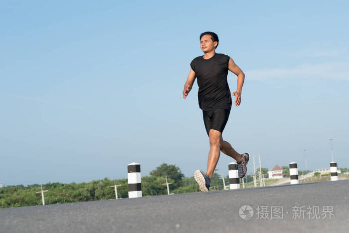 亚洲年轻人奔跑在时间在日出期间在水坝路锻炼.健康的生活方式