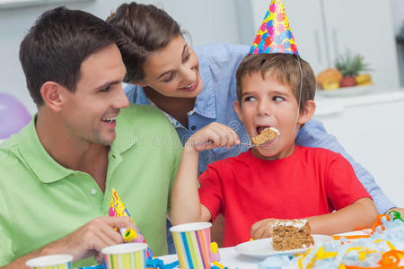 小男孩和父母一起吃生日蛋糕