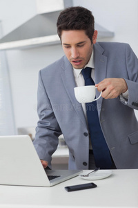 商人边喝咖啡边用笔记本电脑