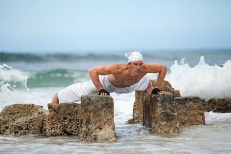 健康人在沙滩上练习普拉提瑜伽