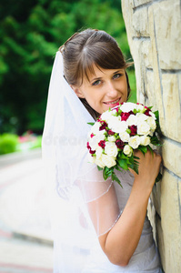 美丽幸福的新娘身穿白色婚纱，带着结婚花束
