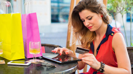 有信用卡的年轻美女卡。她坐在咖啡馆里。