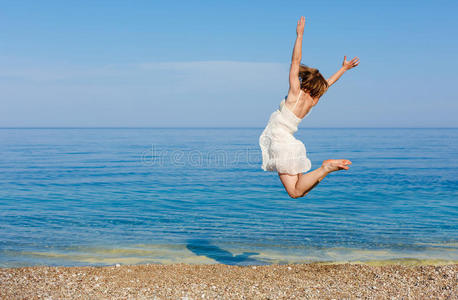 年轻女子在海滩上跳跃