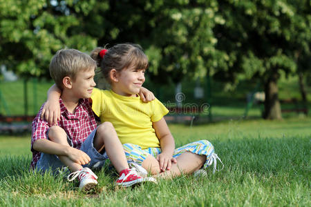 坐在草地上的男孩和女孩