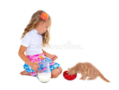 用牛奶喂小猫的小女孩