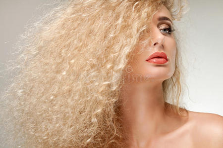 美丽的金发女人的肖像。健康的长卷发。